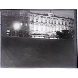 Wain's Hotel and Brown Ewing and Company building at night, and horse-drawn cab, looking from Liverpool Street across Princes Street, Dunedin