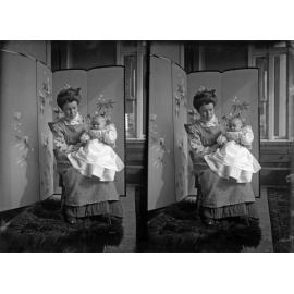 Ethel McGeorge holding Alison McGeorge in front of screen