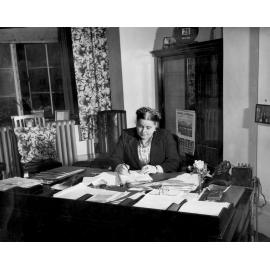 Mabel Howard writing at her desk