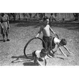 Boys diving through 'hoops' of bicycle tyres