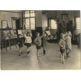 Children in dance poses inside kindergarten