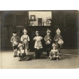 Children wearing hats, holding drums and cymbals