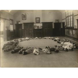 Children lying in circular formation on kindergarten floor