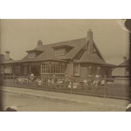 Kindergarten building with children and women outside