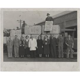 Staff members standing in front of and behind a record shipment of rabbit skins