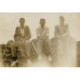 Three young men on wall