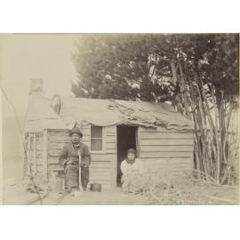 Jack Mamaru and unidentified wahine Māori in front of dwelling