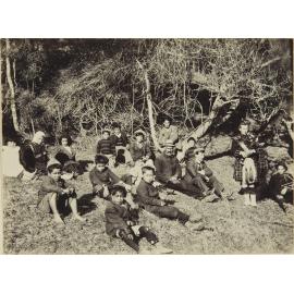 Group of adults and children on a grassy bank