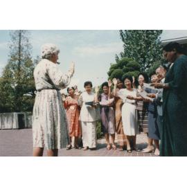 Professor Coleman in front of a group of people [taking a collective oath?]