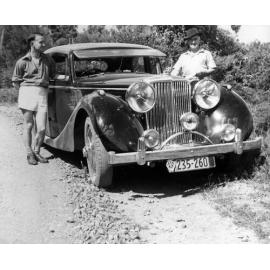 Ernie Webber with an unidentified man next to Webber's 3 1/2 litre Jaguar motor car, 'The Wicked Lady'