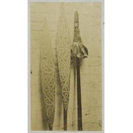 Two painted canoe paddles and a taiaha