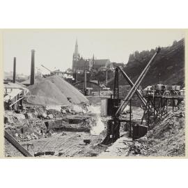 View of cranes and large mountains of loose soil