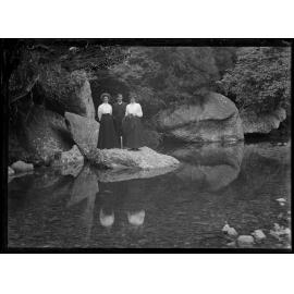 Three people beside the river