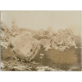 Tripod camera and man beside boulders, Castle Hill