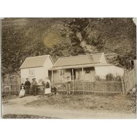 Family outside their corrugated iron homestead