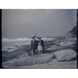 Two women, young boy and dog beside the sea