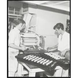 Two men at machine turning out rolled pastry in Laurenson's Bakery 