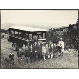 Children and driver standing in front of a bus on the Leith Saddle