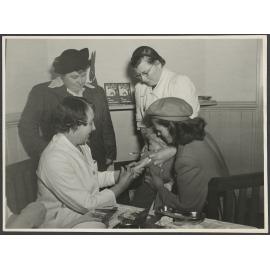 Mabel Howard with two medical staff, child, and caregiver [at a medical clinic]