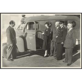 Five people standing next to St John ambulance, 'Queen'