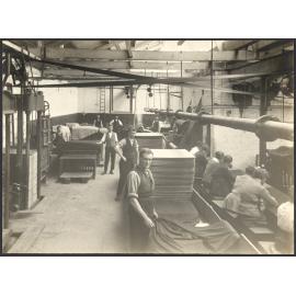 Men folding/stacking cloth and women darning cloth