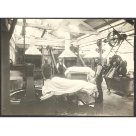 Male workers with cloth and machinery