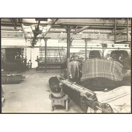 Male workers with piles of blankets and warping looms