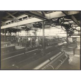 Workers with machines, winding yarn onto cones or pirns for either weaving or knitting