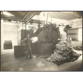 Two workers and machinery, wool being carded into roving