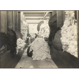 Bales of washed white and dark fleece with worker