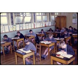 Boys seated at desks in classroom