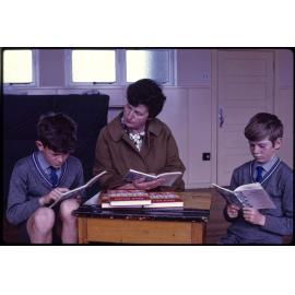 Two boys and teacher, reading