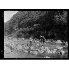 Three boys playing in a stream