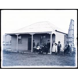 Twelve people outside a house