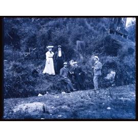 Group of five people next to a steep bank