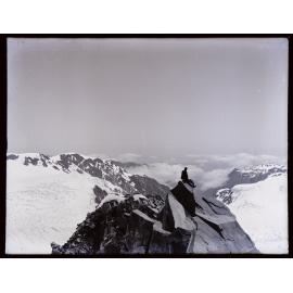 Person seated on rock, looking west, upper Fox Glacier / Te Moeka o Tuawe