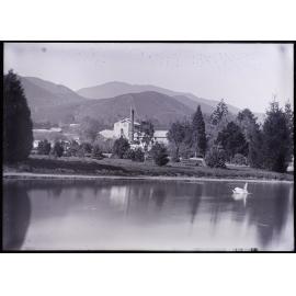 Unidentified factory buildings, viewed from across a river 