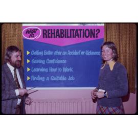 Rehabilitation League staff with sign titled 'What is Rehabilitation?'