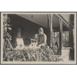 [Eunoe Stamers-Smith?] sitting on porch 