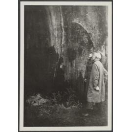 Two people studying a rock wall