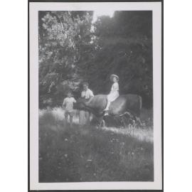 A man with two children and a cow