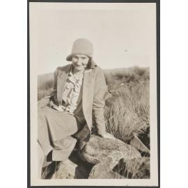 Unidentified woman sitting on rocks