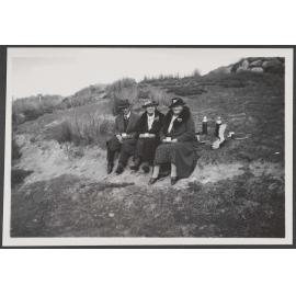 Three people sitting outside