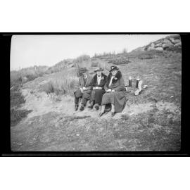 Three people sitting outside