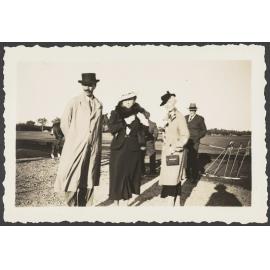 Group of people in field with polo mallets on right