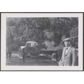 Man next to a truck and a horse