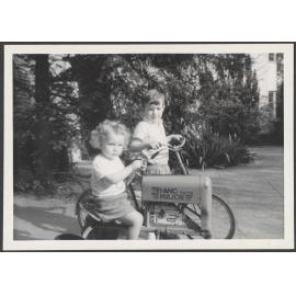 Two children with a toy tractor