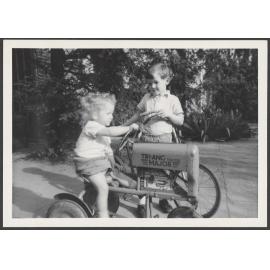 Two children with a toy tractor