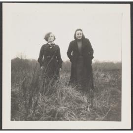 Two girls standing in long grass [Edna and Connie]