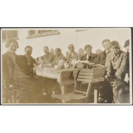 Esmond de Beer with eight unknown people around a table